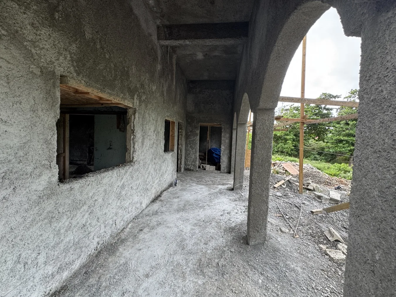 Unfinished arched veranda at The Cove with surrounding tropical foliage