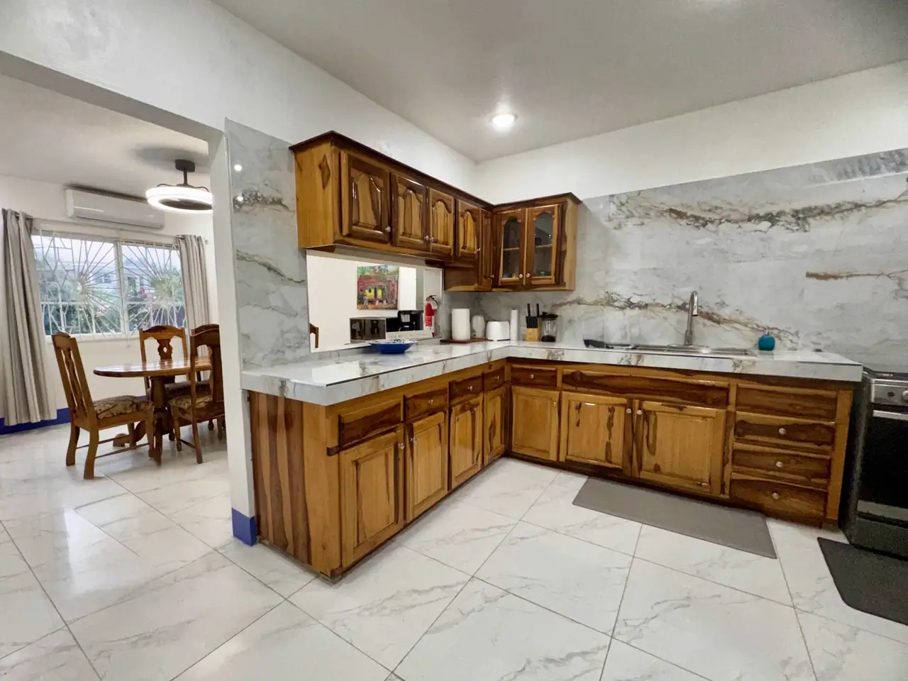 Updated Serendipity kitchen with natural wood cabinetry and stone-look counters
